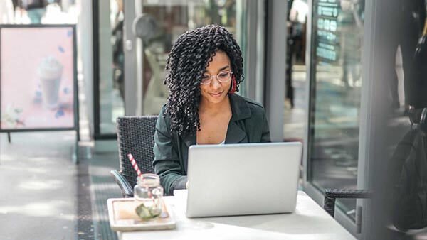 Black young woman writing on computer