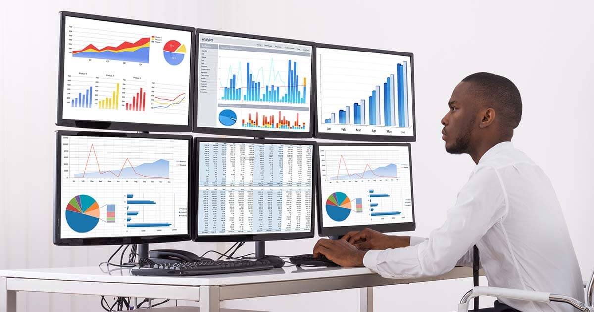 Black person looking at charts on screen - Stock market photo